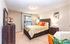 Inviting bedroom with modern decor, featuring a plush bed with vibrant pillows, a stylish wooden dresser, and soft lighting.