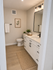 Chic bathroom featuring a modern white vanity with black accents, elegant lighting, and tasteful decor.