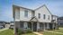 Charming duplex with modern exterior featuring a combination of brickwork and siding, set in a well-maintained neighborhood with lush greenery.