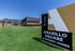 Modern Amarillo Square Apartment Homes sign with sleek architecture and lush green lawn under a clear blue sky.