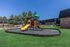 Inviting outdoor playground with vibrant slides and climbing structures, surrounded by lush greenery and modern apartment buildings.