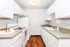 Bright and modern kitchen featuring sleek white cabinets, a pristine countertop, and stylish decor accents.