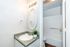 Elegant bathroom with a lighted mirror, modern vanity, and inviting shower area accented by a lush green plant.