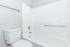 Bright and modern bathroom featuring a sleek white bathtub with chrome fixtures and a minimalist toilet design.