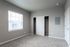 Bright bedroom with plush carpet, sliding closet doors, and a large window inviting natural light.