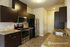 Modern kitchen with dark wood cabinetry, stainless steel appliances, and elegant stone countertops, perfect for culinary creations and entertaining.