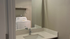 Elegant apartment utility nook showcasing a sleek marble countertop with built-in sink and modern washer conveniently placed beneath shelving.