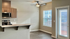 Bright and modern kitchen area with sleek stainless steel appliances, elegant wood cabinetry, and natural light streaming through large windows.