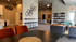 Modern apartment interior featuring a bright and spacious open-concept living area with eclectic wall art, elegant shelving, and cozy seating arrangements.