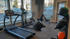 Bright, modern gym with state-of-the-art cardio machines, weight bench, and medicine balls, offering a premium fitness experience.