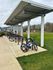 Modern apartment complex with a covered bike rack and neatly manicured green space, promoting a healthy and active lifestyle.