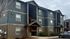 Modern apartment exterior with stylish two-story design, lush landscaping, and convenient parking.