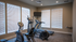 Modern fitness room featuring state-of-the-art exercise equipment with natural light streaming through large windows.