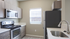 Modern kitchen with sleek stainless steel appliances, elegant cabinetry, and ample natural light from a bright window.