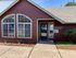 Inviting leasing office with charming red exterior and large windows, welcoming potential tenants.