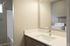 Modern bathroom with sleek countertop and spacious laundry area featuring a washer and dryer for convenient living.