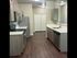 Modern kitchen with sleek cabinetry, stainless steel appliances, and rich wood flooring, offering a blend of style and functionality.