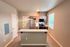 Modern kitchen with stainless steel appliances, stylish cabinets, and a sleek countertop under warm recessed lighting.