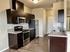 Modern kitchen with sleek dark wood cabinets, stainless steel appliances, and granite countertops, perfect for culinary enthusiasts.