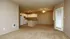 Inviting open-concept living space with cozy carpet flooring and a well-equipped kitchen, perfect for entertaining and relaxation.
