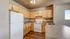 Bright and spacious kitchen with modern white appliances, abundant wooden cabinetry, and sleek countertops, ideal for cooking enthusiasts.