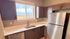 Bright kitchen space featuring modern stainless steel appliances, elegant dark wood cabinets, and a beautiful view from the window.
