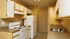 Inviting kitchen with ample cabinet space, electric stove, and refrigerator, offering functionality and modern design.