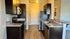 Contemporary kitchen with sleek dark cabinets, stainless steel appliances, and granite countertops.