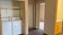 Convenient apartment hallway featuring in-unit washer and dryer, elegant wood flooring, and access to bedroom and bathroom.