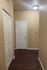 Inviting hallway in modern apartment featuring elegant hardwood floors and stylish white doors, creating a warm and welcoming entrance.