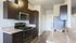 Modern kitchen with sleek dark wood cabinets, stainless steel appliances, and elegant granite countertops.