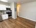 Modern apartment kitchen with sleek stainless steel appliances and elegant wood flooring.