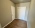 Modern entryway featuring sleek hardwood floors, neutral walls, and ample closet space with white sliding doors.