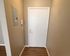 Welcoming apartment entryway with elegant wood flooring and sleek white door.