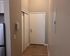 Welcoming apartment entryway with sleek hardwood flooring, neutral wall tones, and modern accents.