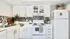 Modern kitchen with sleek white cabinets, hexagonal tile backsplash, and stylish countertop decor.