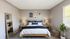 Elegant bedroom with modern decor, featuring a comfortable bed with navy accents, stylish artwork, a large mirror, and abundant natural light.