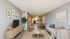 Contemporary open-concept living room with sleek furnishings, cozy seating, and elegant decor leading to a modern kitchen.