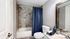 Elegant bathroom with modern tiled shower, sleek vanity, and designer accents featuring plush towels and decorative plants.
