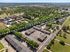 Aerial view showcasing Longleaf Trace apartments amidst lush greenery, with recreational and sports facilities nearby.
