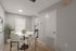 Modern dining area with elegant round table, neutral chairs, and bright lighting, blending into a cozy open kitchen; perfect for stylish gatherings.