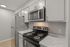 Modern kitchen featuring sleek stainless steel appliances, pristine marble countertops, and contemporary cabinetry.