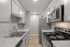 Modern kitchen with sleek stainless steel appliances, marble countertops, and ample cabinet space.