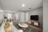 Modern living room with elegant decor, featuring a cozy white sofa, chic marble coffee table, and a sleek mounted TV, leading to a dining area with abundant natural light.