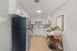Modern kitchen with sleek white cabinetry, stainless steel appliances, and a chic dining area with a marble table and stylish chairs.