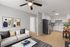 Modern open-plan living room and kitchen space with stylish decor, cozy seating, and sleek stainless steel appliances.