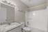 Modern bathroom featuring elegant granite countertops, sleek fixtures, and a pristine bathtub for a luxurious experience.