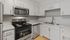 Modern kitchen with sleek stainless steel appliances, white cabinetry, and elegant marble countertops.