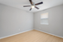 Bright and spacious room with modern ceiling fan and elegant wood flooring, perfect for a cozy living space.