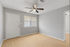 Bright and inviting room with fresh gray walls, elegant hardwood floors, and a modern ceiling fan, perfect for a cozy living area.
